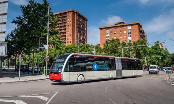 An electric bus traveling through the city streets of Barcelona